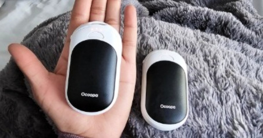 person holding black and white Rechargeable Hand Warmers in hands