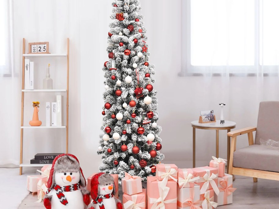 Snow Flocked Christmas Tree surrounded by presents