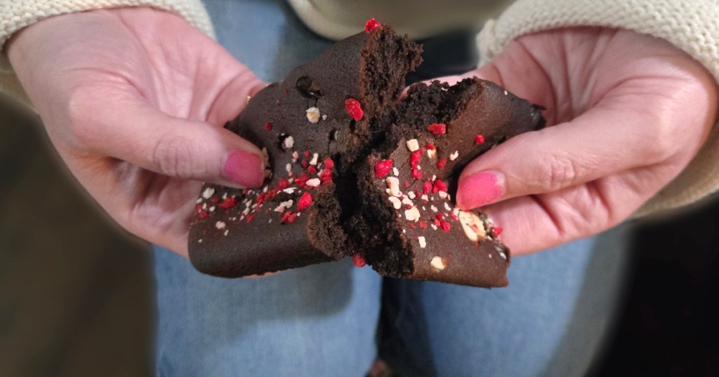 woman holding subway cookie split in half