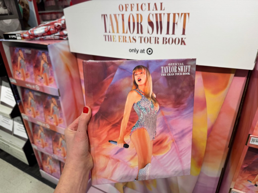 person holding up Taylor Swift Eras Book in target store