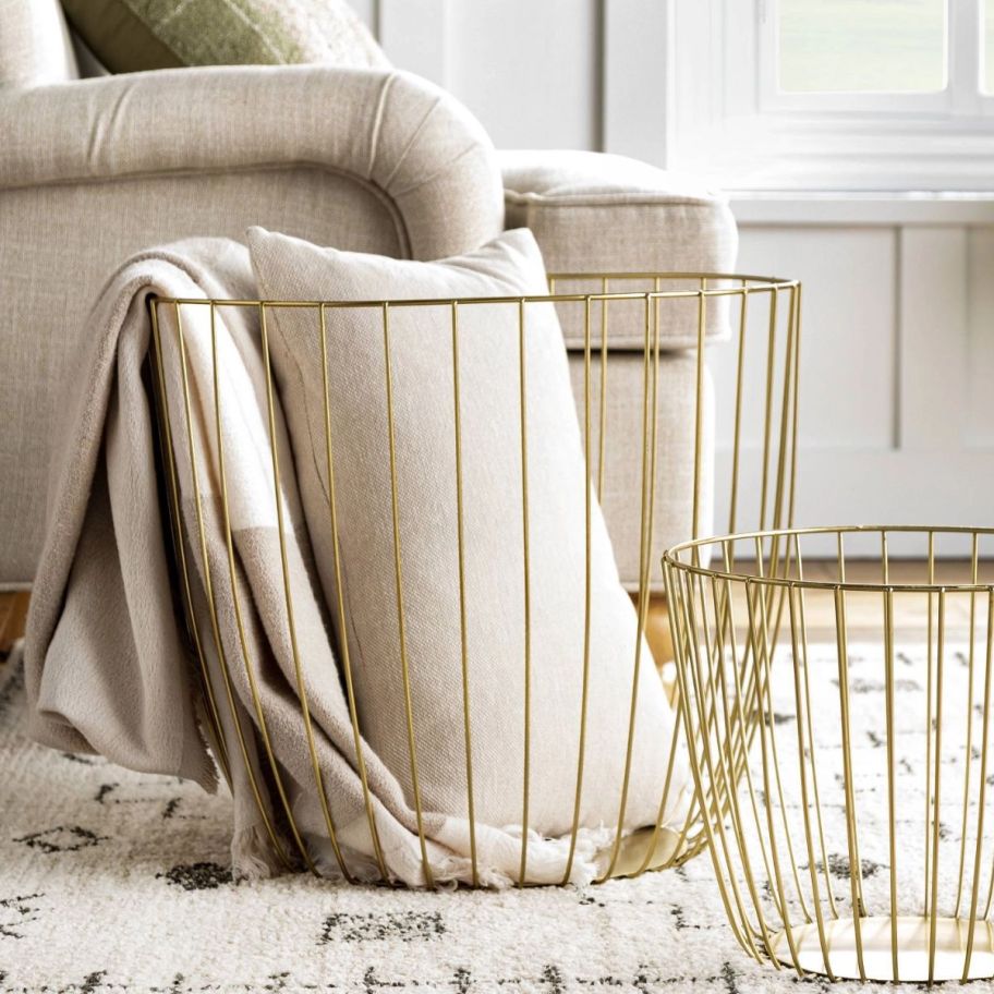 gold wire basket with blankets in it