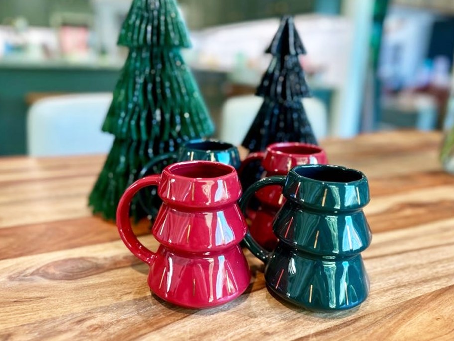 set of 4 green and red tree shaped coffee mugs on wood table