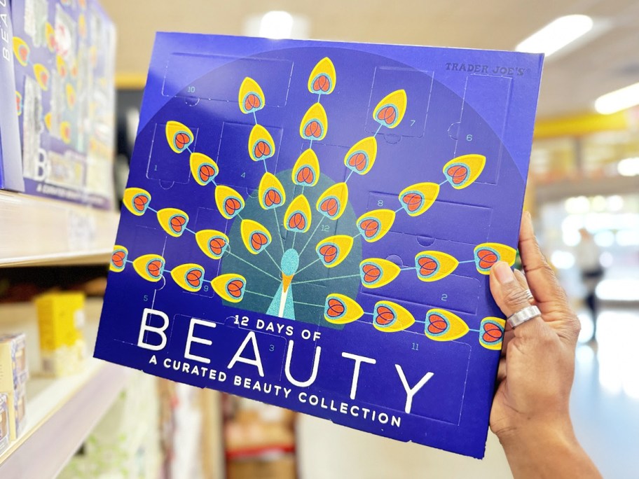 hand holding up Trader Joe's 12 Days of Beauty Advent Calendar in store