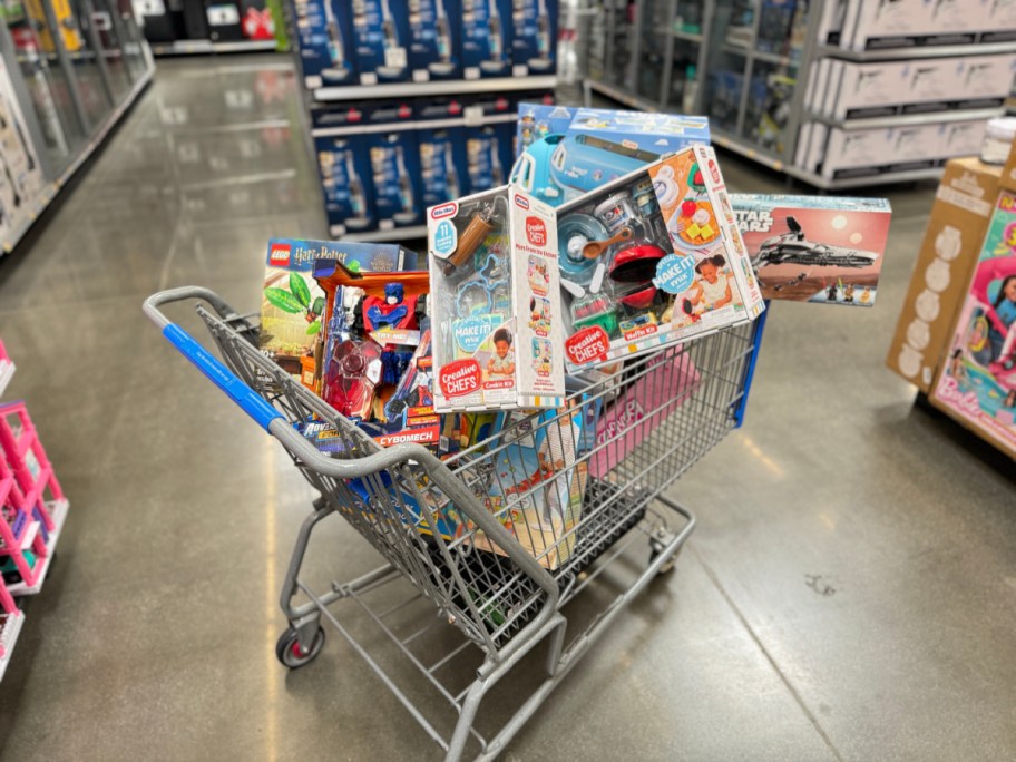 Walmart shopping cart full of different toys in store aisle