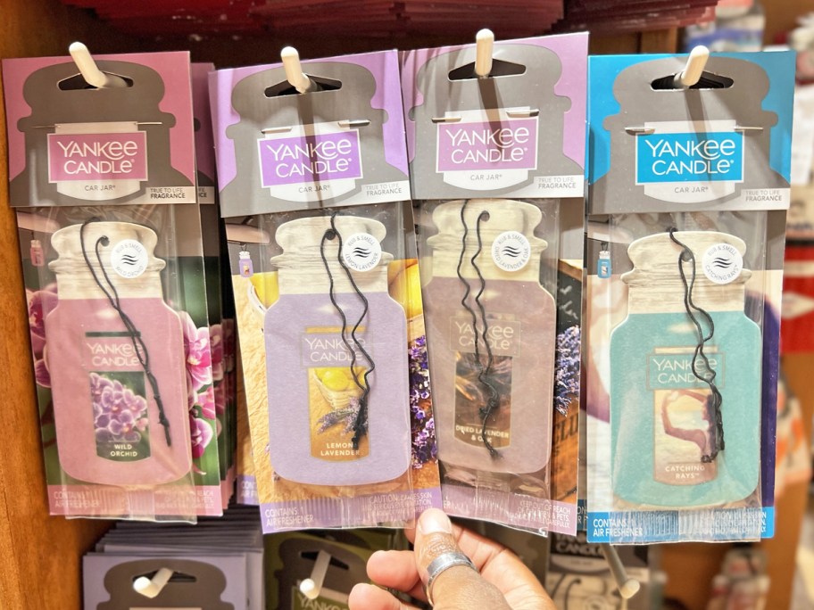 hand touching display of Yankee Candle Hanging Car Jar Air Fresheners