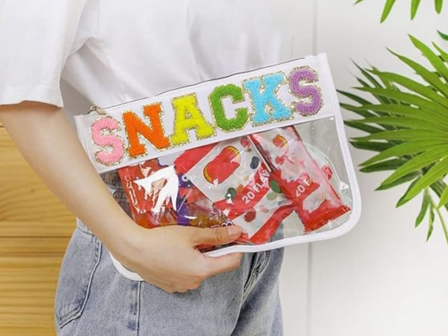 person holding Zipper Pouch - White Snacks with snacks inside