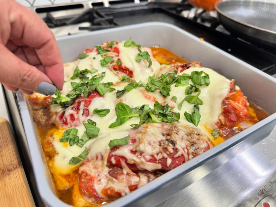 adding fresh basil to chicken dish