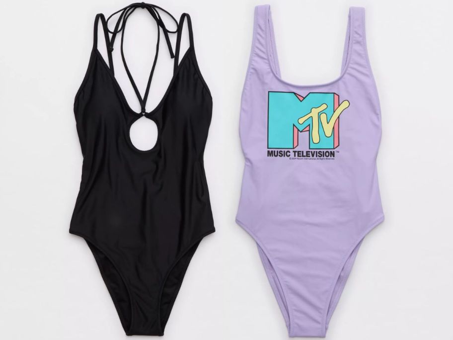 a black one piece swimsuit shown with a purple one piece.