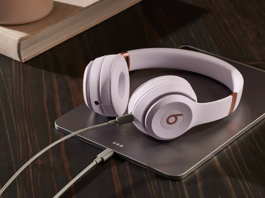 pink headphones sitting on table with tablet