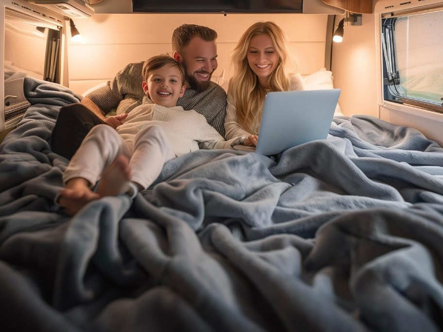 family on bed with large gray blanket