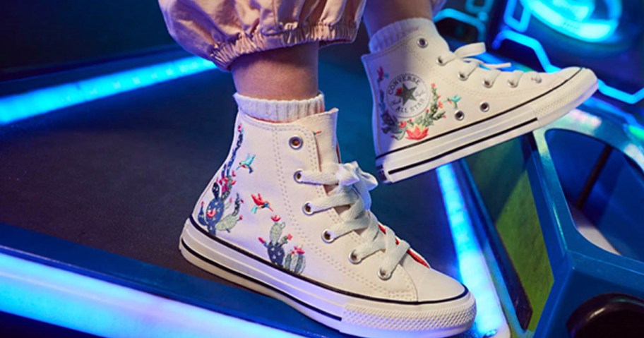 kid wearing white cacti embroidered shoes 