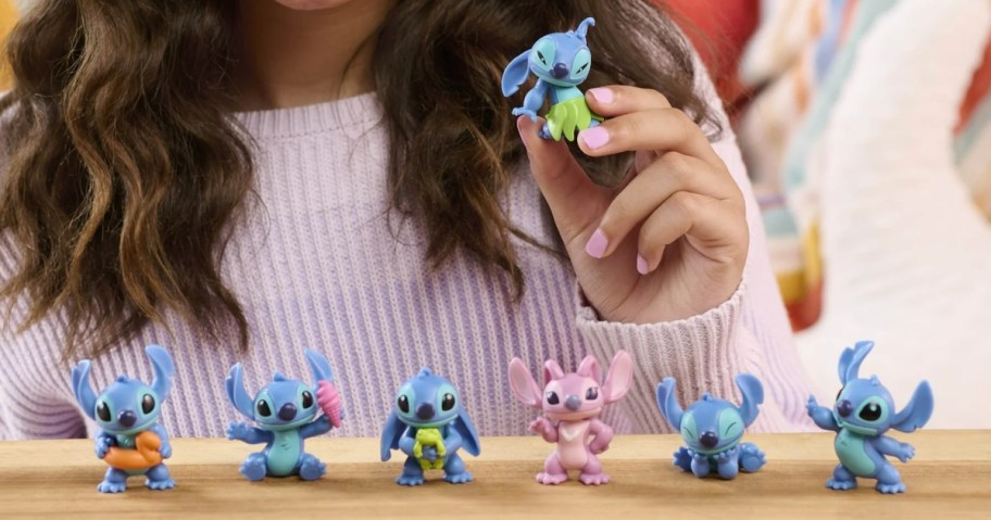 little girl playing with a Disney Stitch and Angel mini figure set