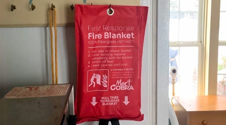 a fire blanket hanging from a coat hook by the back door