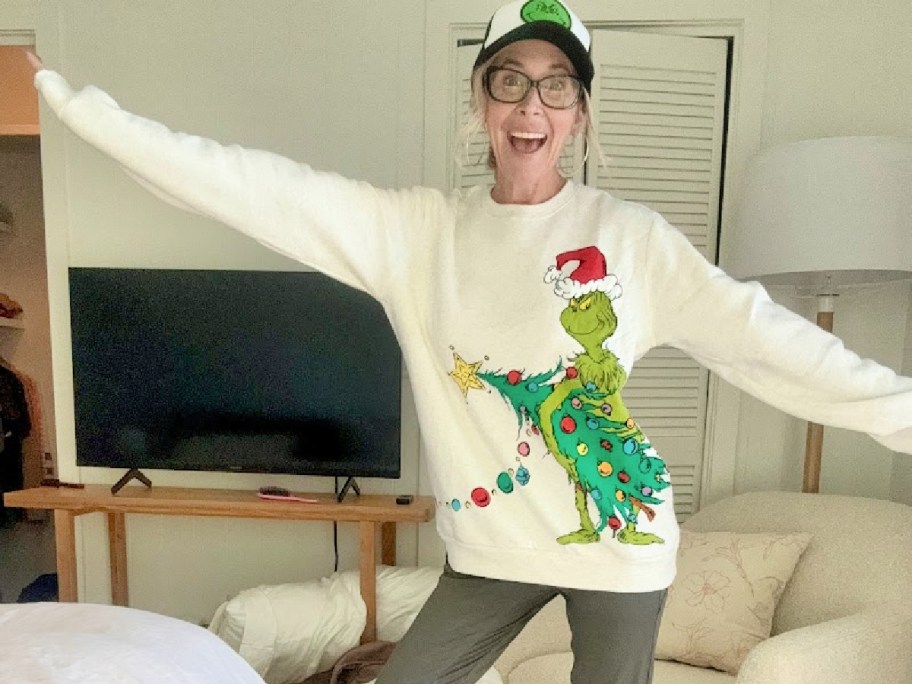 woman posing in a grinch sweatshirt