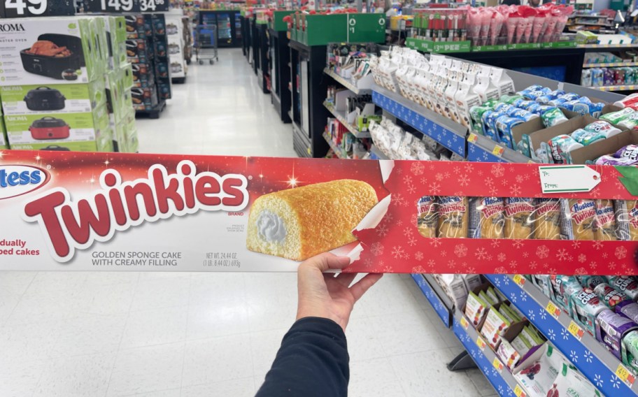 hand holding a giant box of twinkies in a walmart store