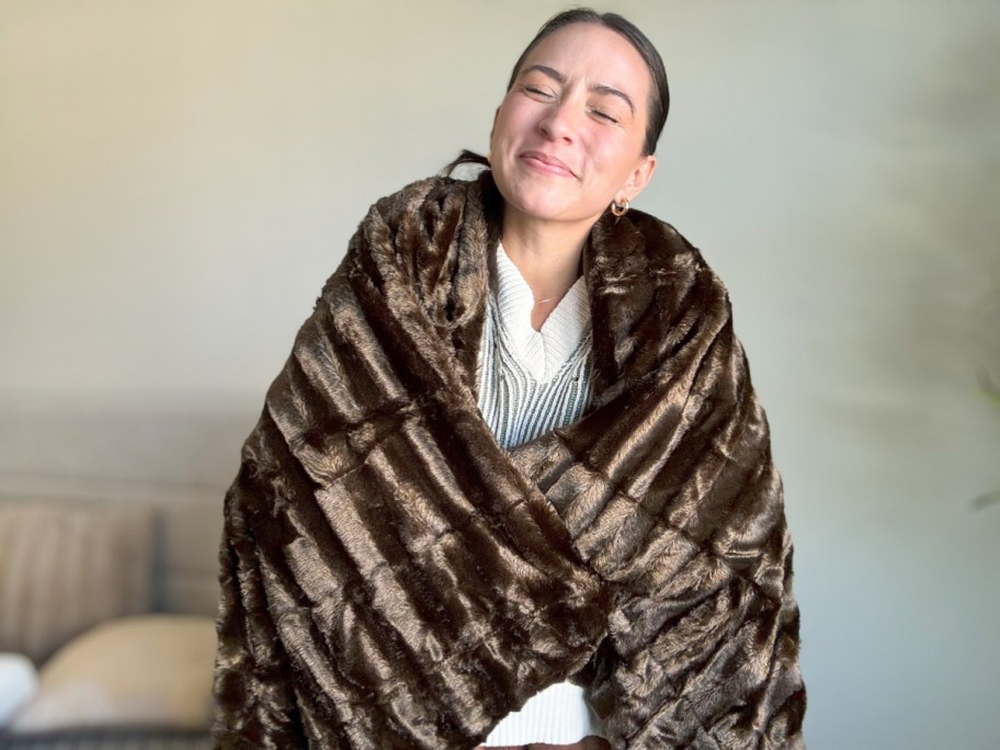 woman wrapped in brown ribbed throw blanket