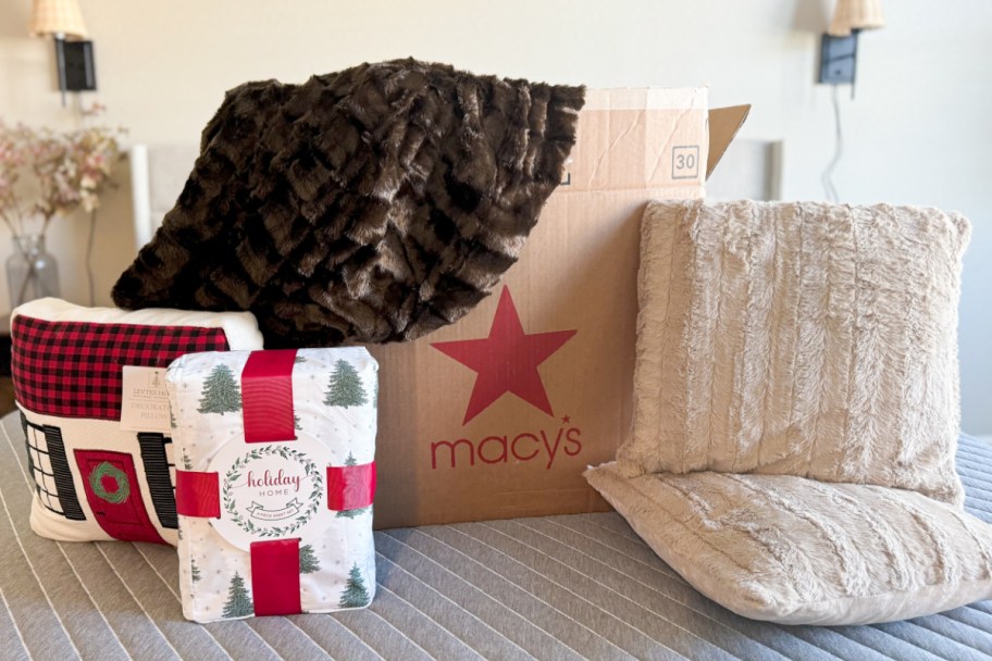 sheets, throw pillows, and blankets next to macys box