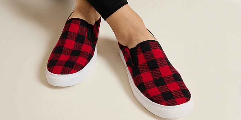 person wearing black and red plaid slip on shoes 