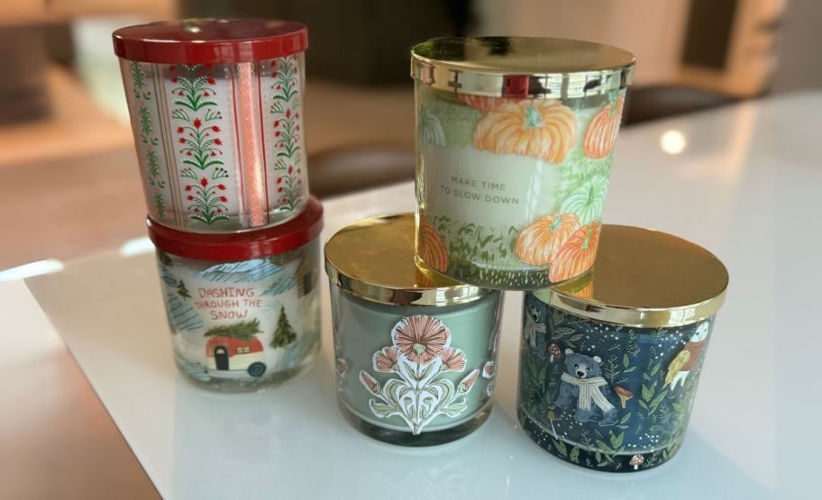 assorted 3 wick holiday candles on a kitchen countertop