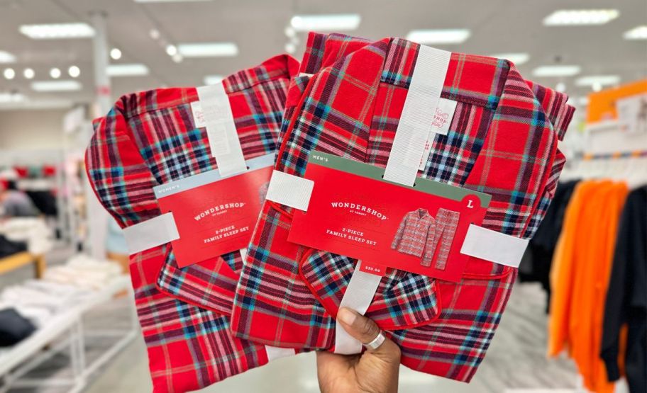 hand holding adult and kids sets red plaid family matching pajamas in Target