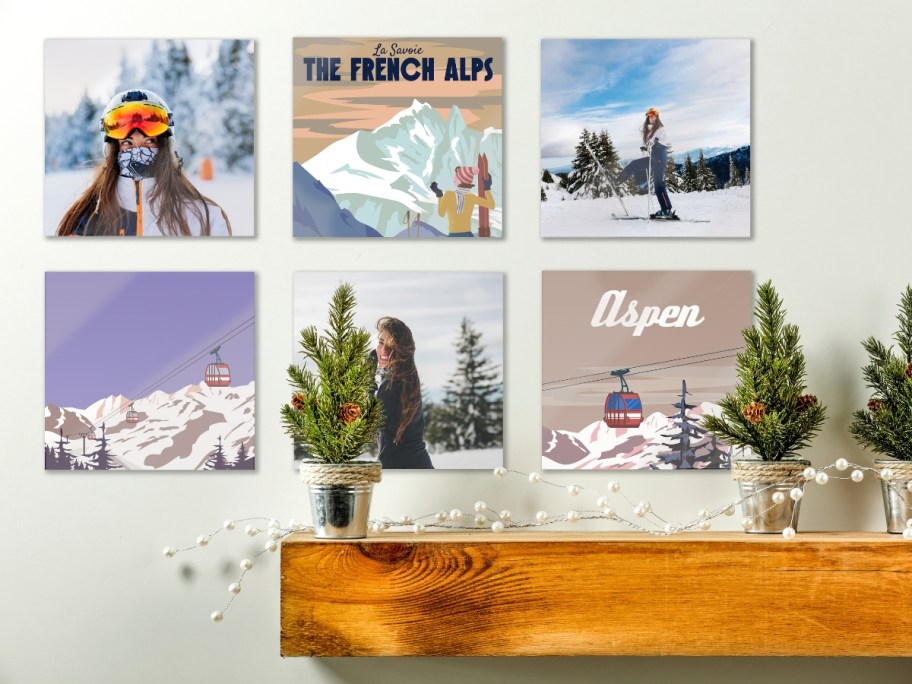 a wall with glass photos of a person in the snow and mixed poster style images of Aspen, Co, accent table with decor sits below it