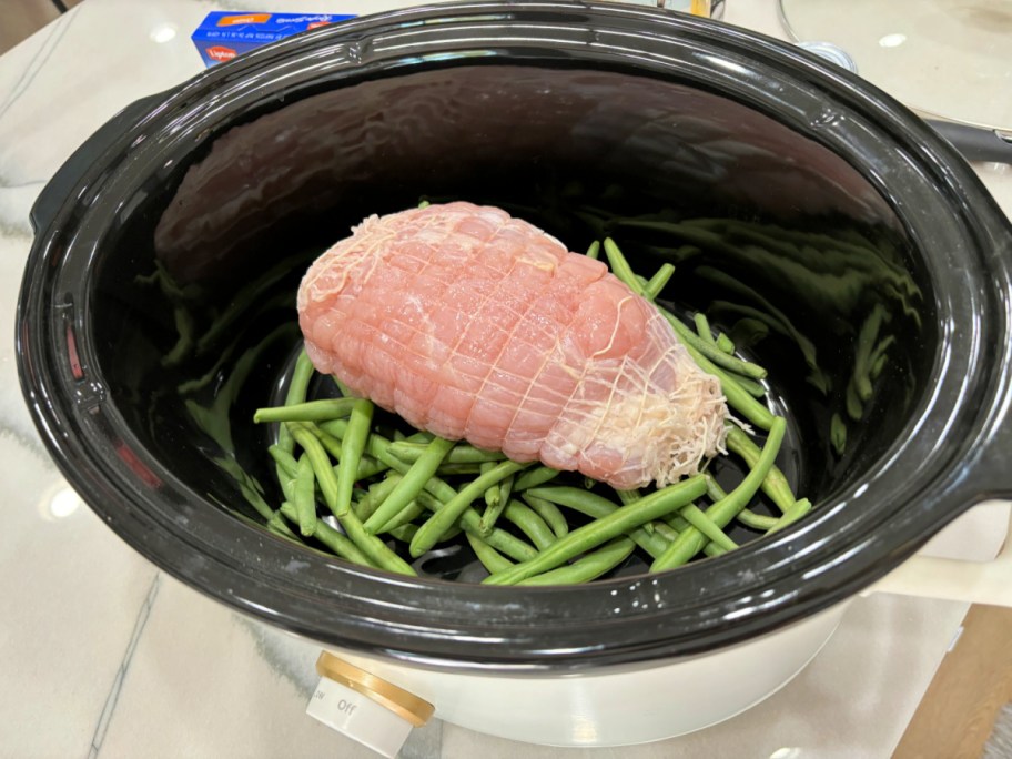 turkey breast inside a slow cooker with green beans 