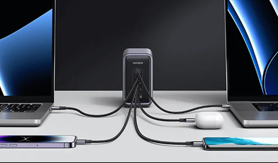 gray desktop charger with laptop, phones and airpods plugged in 