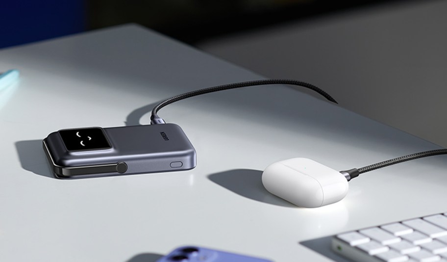 gray charger with airpods plugged in on table