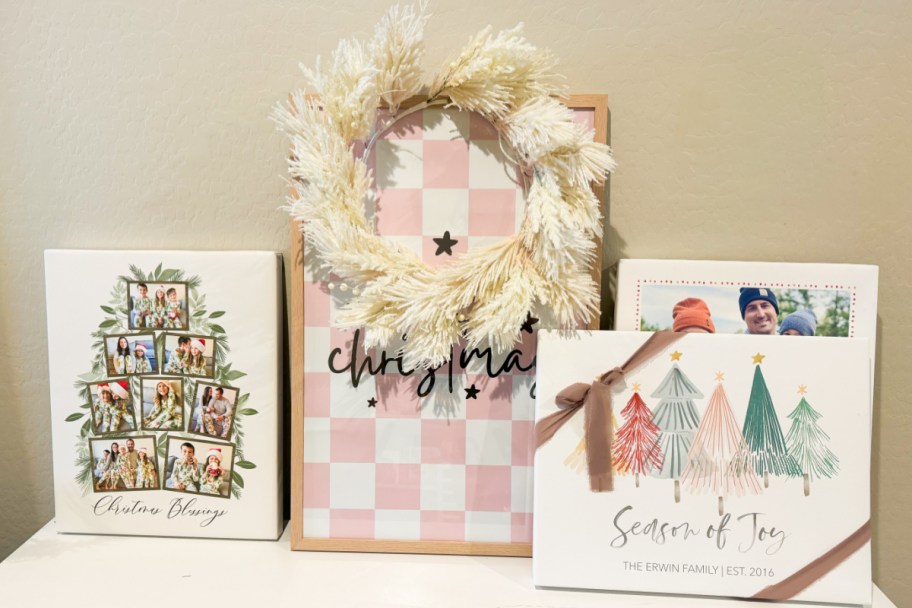 many christmas canvases on shelf