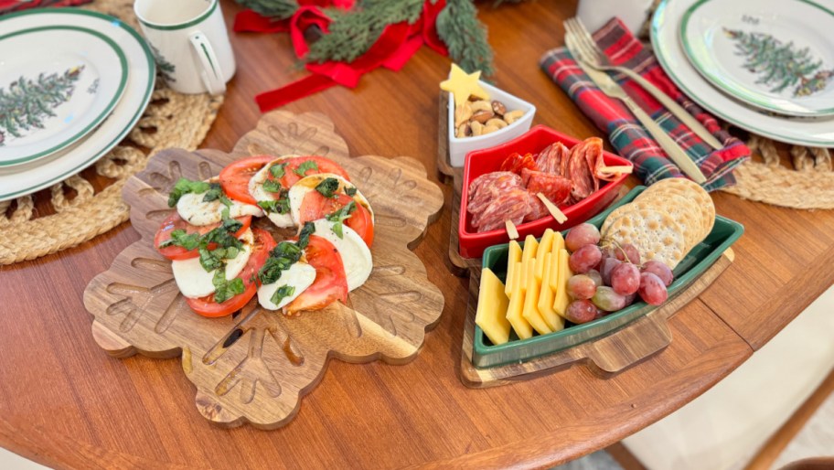 snowflake and christmas tree charcuterie serving boards filled with food on a table