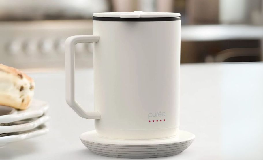 a warming coffee mug with coaster on a kitchen counter