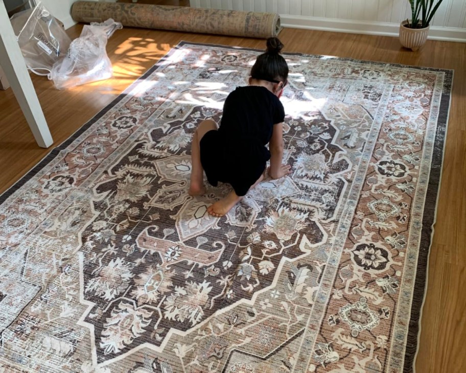 girl sitting on vintage washable rug