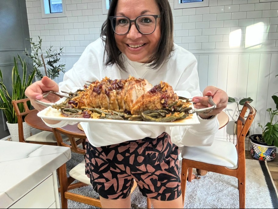 woman holding a tray of slow cooker turkey breast