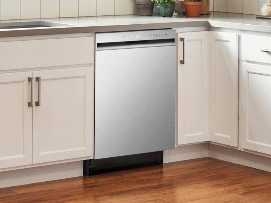 a stainless steel dishwasher in a kitchen with cream color cabinets