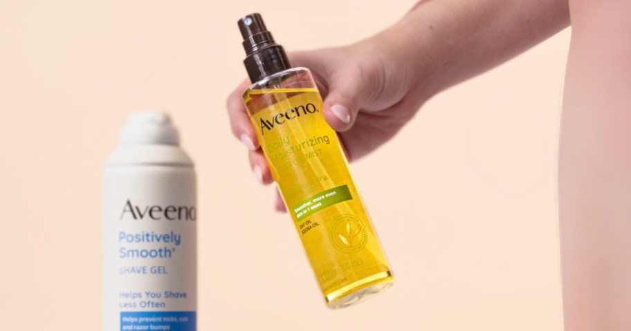 woman holding aveeno daily moisturizing oil mist bottle