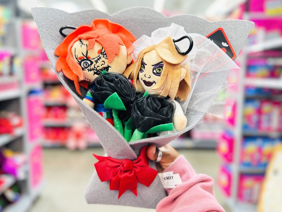 hand holding up Chucky & Tiffany 5-Piece Plush Valentine's Bouquet in store