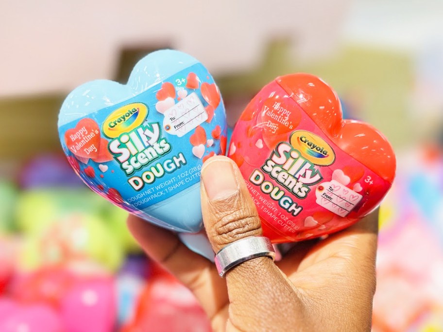 hand holding up blue and red heart shaped Crayola Silly Scents Dough