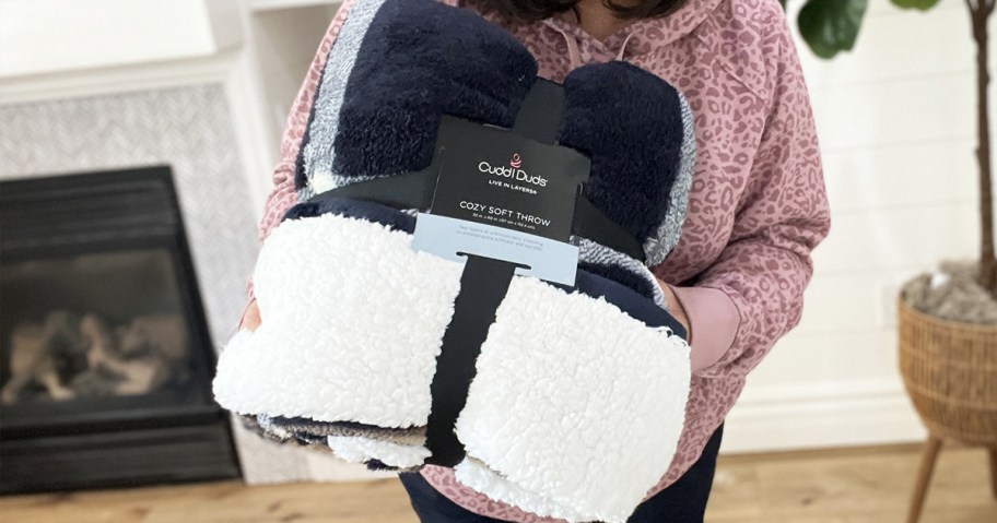 woman holding up a Cuddl Duds Throw