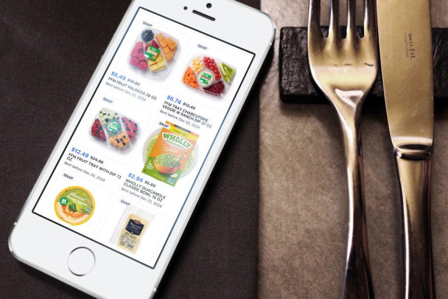 Flashfood app deals shown on a phone next to a fork and knife