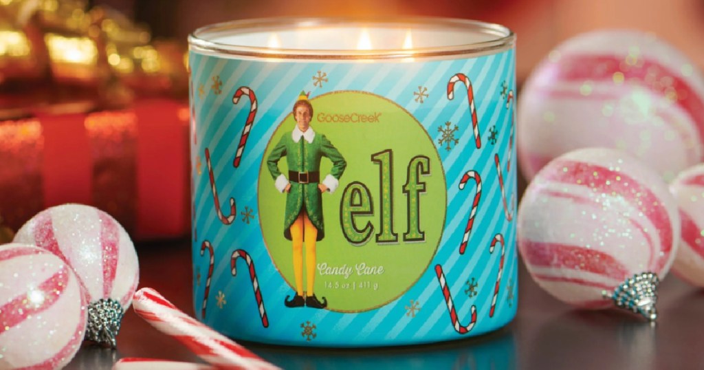 goose creek elf candle burning on table surrounded by peppermint candy