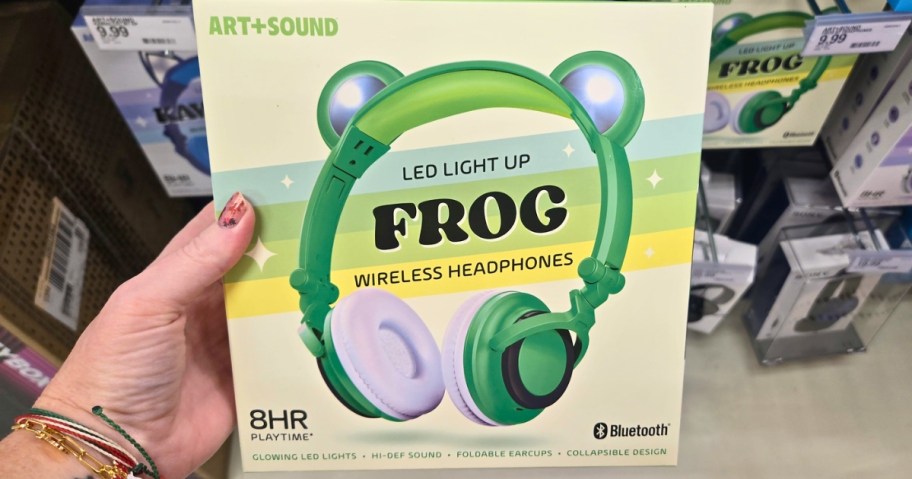 hand holding a box with a pair of green Kids Headphones that have frog ears