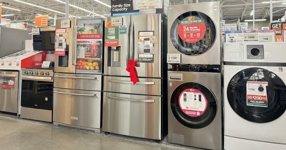 a row of home appliances washer, dryer, refrigerators, dishwashers and ovens in an aisle at Home Depot 