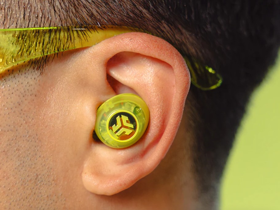 lime green transparent ear bud in ear