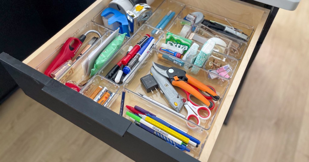 Open desk drawer showing organized junk