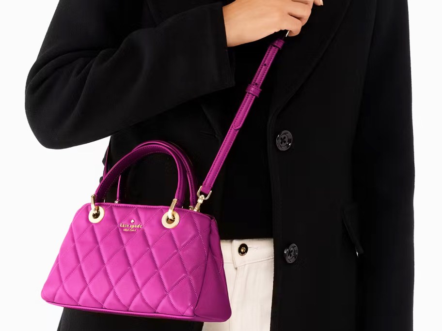 woman in a black jacket with a magenta crossbody bad