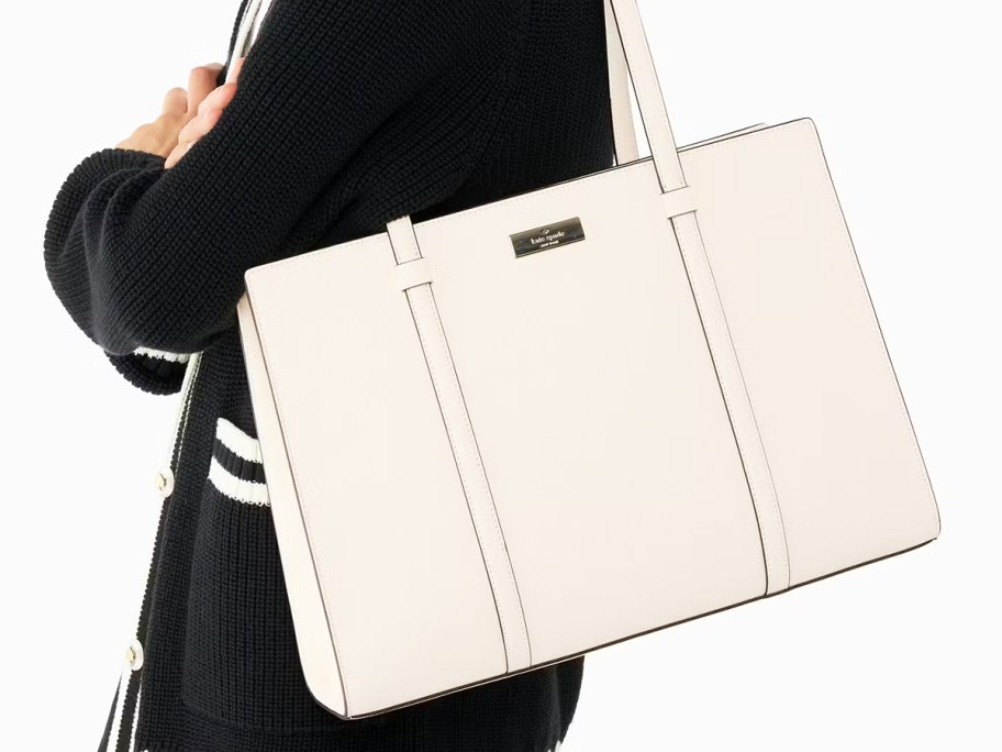 woman in a black sweater with a white tote bag