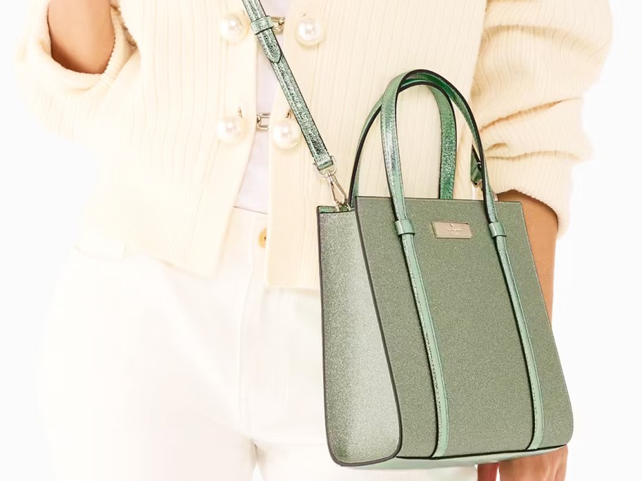 woman in a white sweater with a light green sparkly crossbody bag