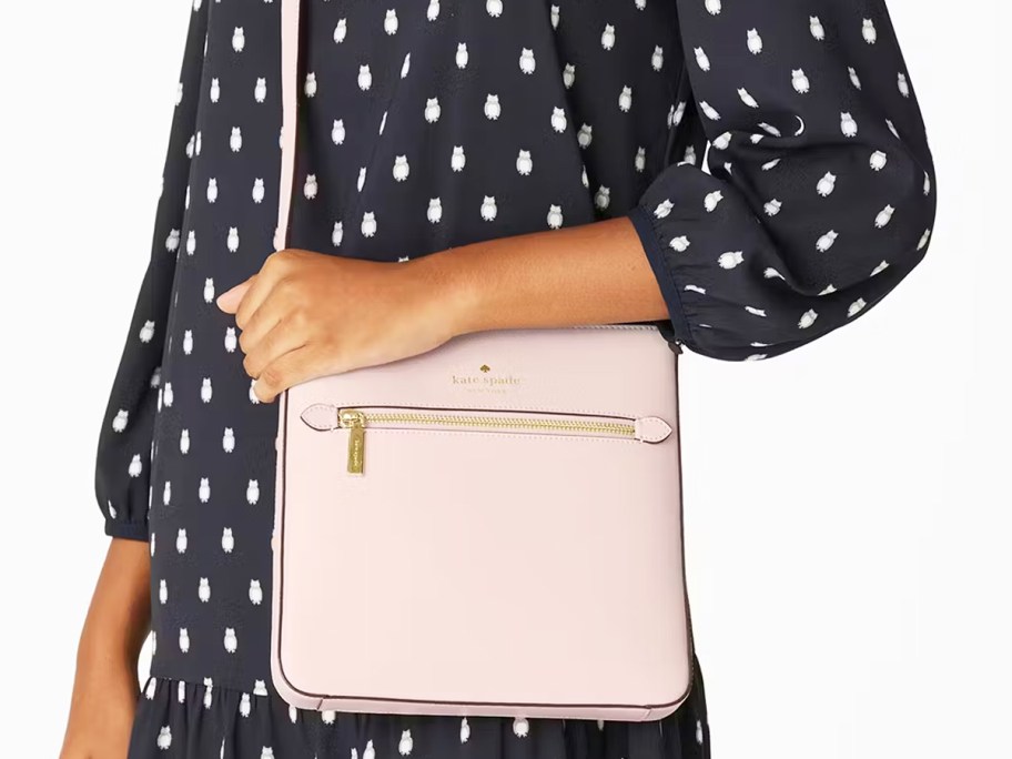 woman in a black dress with a light pink crossbody bag