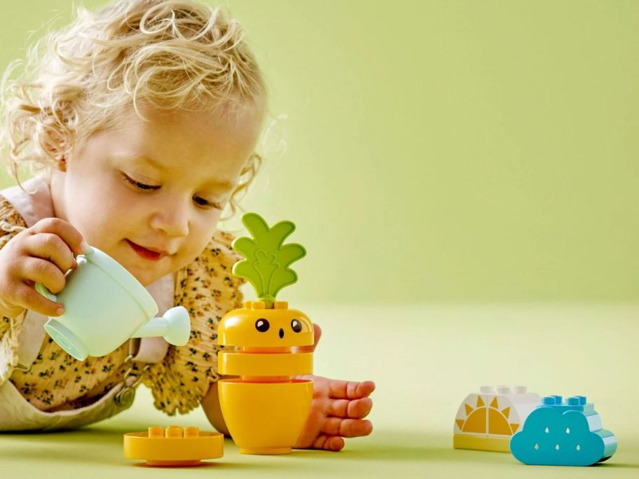 Little girl playing with a LEGO DUPLO My First Growing Carrot