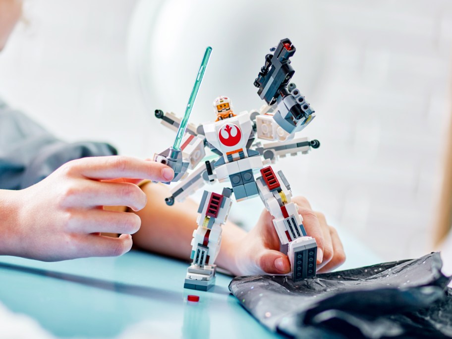 child playing with LEGO Star Wars Luke Skywalker X-Wing Mech Action Figure